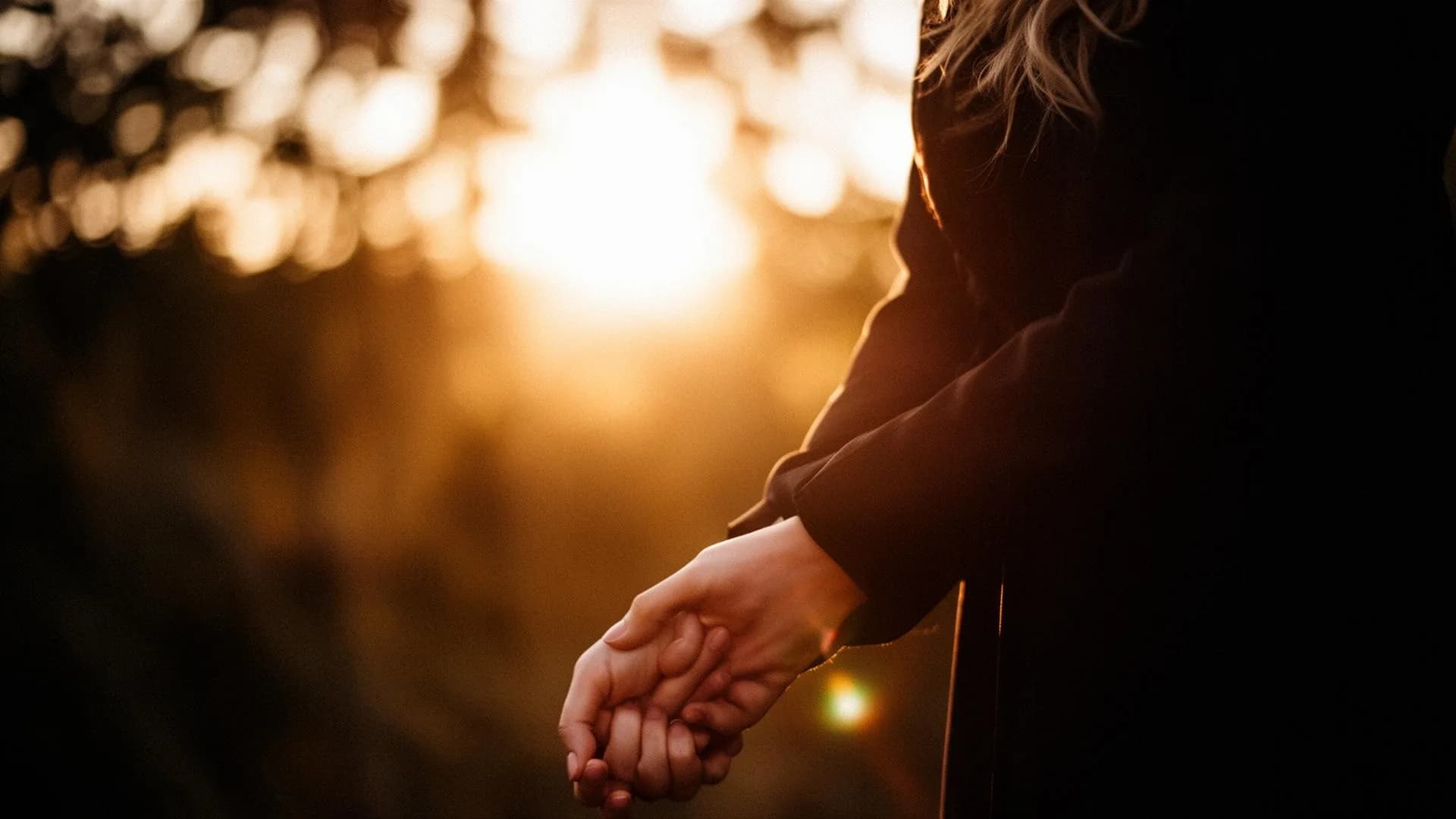 Couple holding hands at golden hour